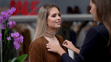 Shop assistant helping customer in clothes shop