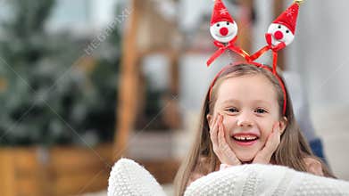 Portrait of little baby girl posing in funny Christmas ears laughing having positive emotion