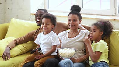 Happy african american family mom dad and kids watching tv