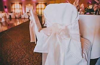 White linen chair covers with blush bows