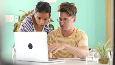 Confused man asking help from coworker in creative office.