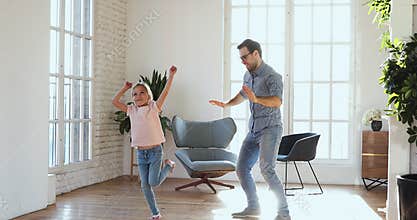 Childish young father showing funny moves to kid daughter.
