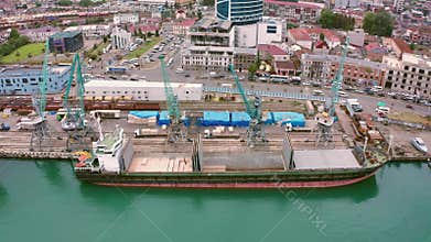 Flight over of the Batumi, Georgia. Bulk cargo ship under port crane, Batumi seaport, Georgia