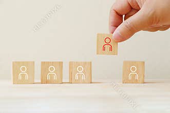 Person icon on wooden cube with hand pick different from them.