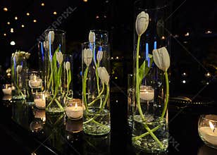 Tulip flowers decoration with candles at night, indoor luxury wedding with low light romantic ambient