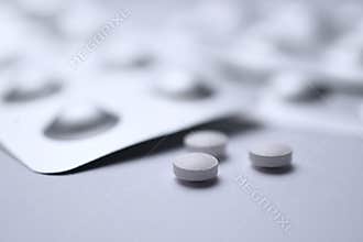 White pill tablet on white table. Virus flu dose of medicine or treatment drug concept