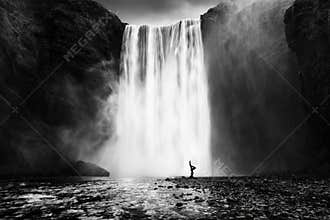 Woman practicing yoga at the Skogafoss waterfall