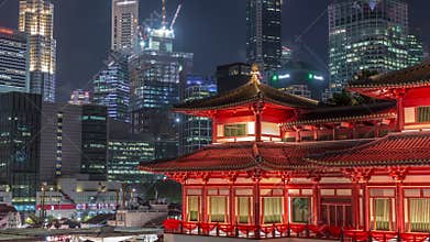 The Buddha Tooth Relic Temple comes alive at night timelapse in Singapore Chinatown, with the city skyline in the
