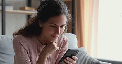 Smiling millennial woman watching video stories on smart phone