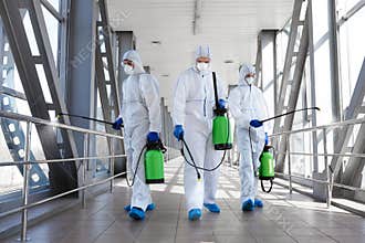 Team of professional virologists in protective suits ready for disinfection