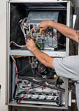 Handyman does furnace repair with tools