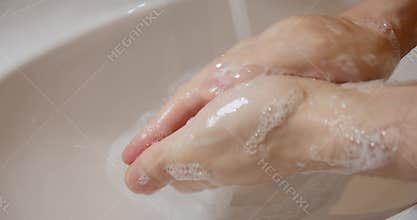 Man washing hands with water and soap foam under faucet. The rules of hygiene