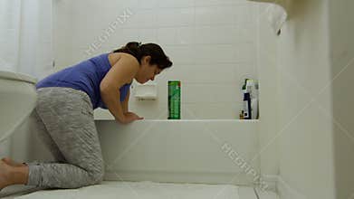 Woman cleaning bathtub during quarantine
