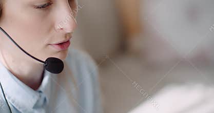 Sales representative in headset speaking to client and making video conference call on laptop.