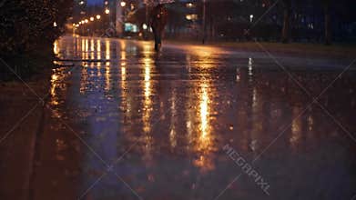 Anonymous People Riding on Electric Scooters Through City Park Boulevard on Rainy Evening