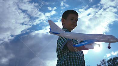 Aspiring Pilot: Boy Playing with Toy Plane on a Sunny Summer Day