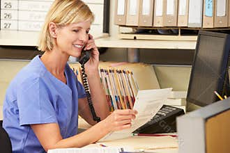 Nurse Making Phone Call At Nurses Station