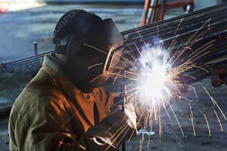 Worker welding with electric arc electrode