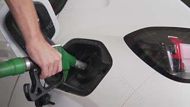 Close-up, a man refueling a car at a gas station