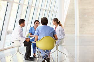 Medical Team Meeting Around Table In Hospital