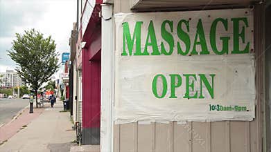 massage open 1030am to 9pm sign in green capital letters on white background