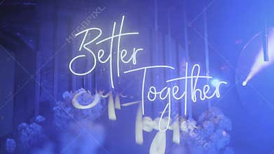 Blue colored neon glowing wedding lettering better together hanging on the wall light spots from disco ball, decoration