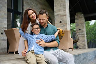 Dad, mom and son, hugging, settled down on e terrace
