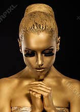 Belief. Styled Woman with praying hands. Golden Makeup