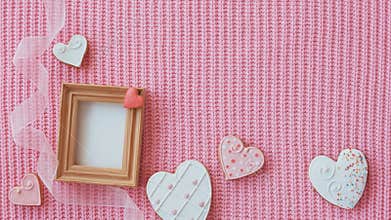 Cute Frame with Clean White paper Inside. Sweet Heart Shaped Gingerbreads and Pink Ribbon. Festive Pink Knitted