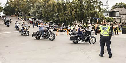 Dense motorcycle traffic controlled by policeman.