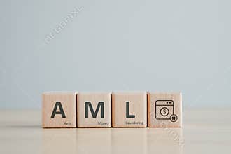 Wooden block with AML text and dollar coin in washing machine. AML - Anti Money Laundering concept.