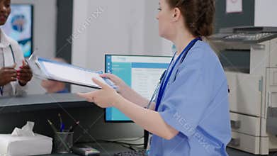 Medical assistant helping doctor with checkup report papers