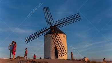 Awe old windmill with blurred people at sunset
