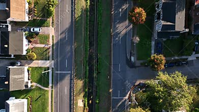 Aerial top view of cars on a road in a green suburban neighborhood on a sunny day on Long Island