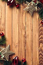 Red and gold Christmas decorations with fir branches on corners borders. Vintage ornaments on rustic wood background