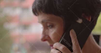 Woman talking on the phone anxiously closeup. Anxiety in older adults. Face eyes