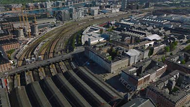 High angle view of central train station building. Tilt up reveal of various town development in urban boroughs along
