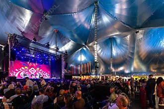 Rushing to the seat, through the ticket control gate to enjoy Indonesian music performance group inside and under a gigantic tent