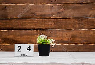 July calendar with number 24. Planner copy space on a wooden brown background. March number icon. Place for text background
