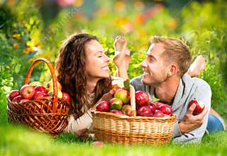 Couple Relaxing on the Grass and Eating Apples