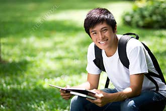 Young handsome Asian student with laptop