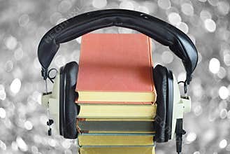 audio book concept with row of books, vintage headphones and bubble balls swirly bokeh