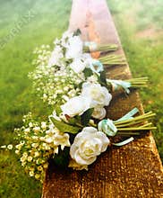 White roses on a bench before a country wedding