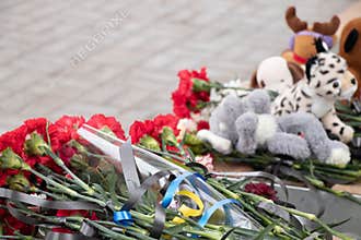 Toys and flowers lie at a trolleybus stop next to a house blown up by a Russian rocket on Pobeda in the city of Dnepr in