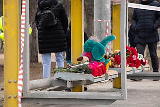 Toys and flowers lie at a trolleybus stop next to a house blown up by a Russian rocket on Pobeda in the city of Dnepr in
