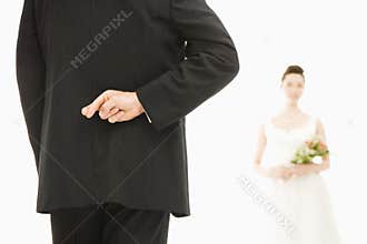 Groom with crossed fingers.
