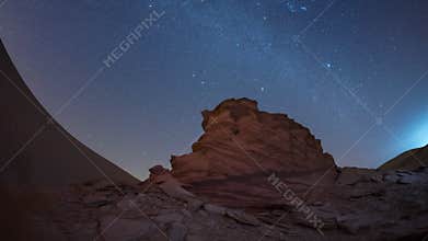 4K Time lapse of night sky milky way while camping in dark universe in desert with rock dune wind erosion.