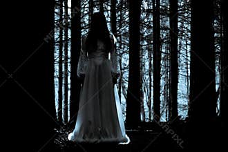 Mysterious girl in dark spooky forest