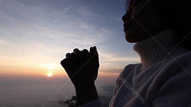 Silhouette of christian woman hand praying, Woman praying in the morning on the sunrise background. spirituality and religion,