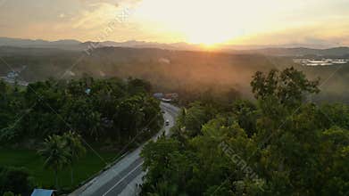 Countryside with tropical plants and road overlooking sunset